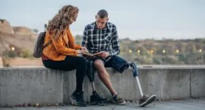 image of two individuals with limb differences reading a book