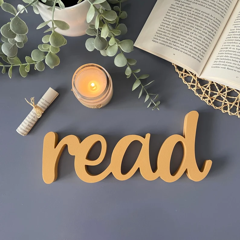 Wooden sign in loopy font that says "read."