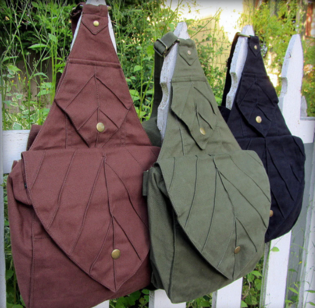 picture of three backpacks that are designed to look like leaves, which come in green, navy blue, and burgundy colors