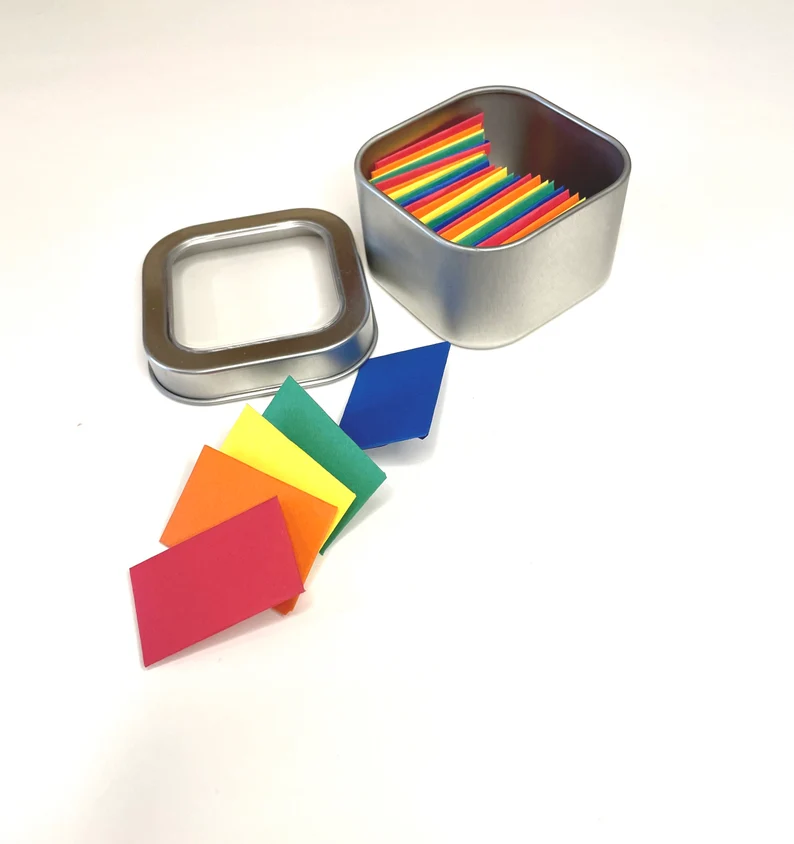 Image of a tin with several colorful tiny paper envelopes inside. 