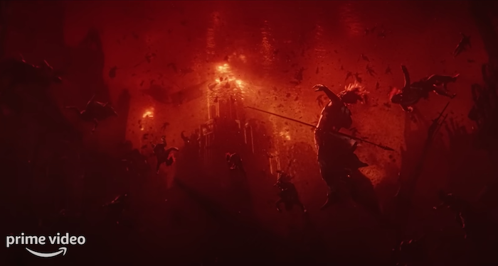 a still from The Rings of Power trailer still in black and red, showing people being thrown around in an apocalyptic scene