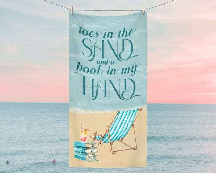 Beach towel with a beach chair and text that says "Toes in the Sand and a Book in My Hand."