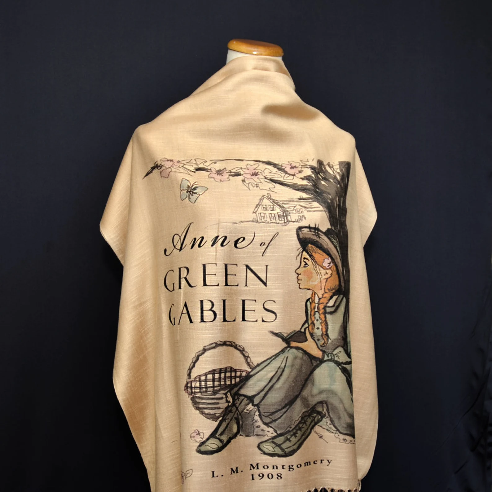 A tan scarf printed with the cover of Anne of Green Gables.