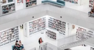big, white library with people sitting and walking around
