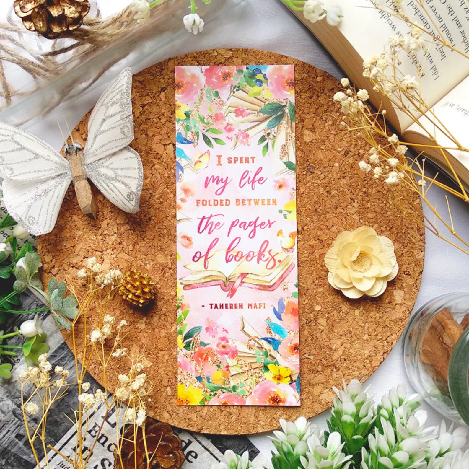 a pink floral bookmark that reads "I spent my life folded between the pages of a book."