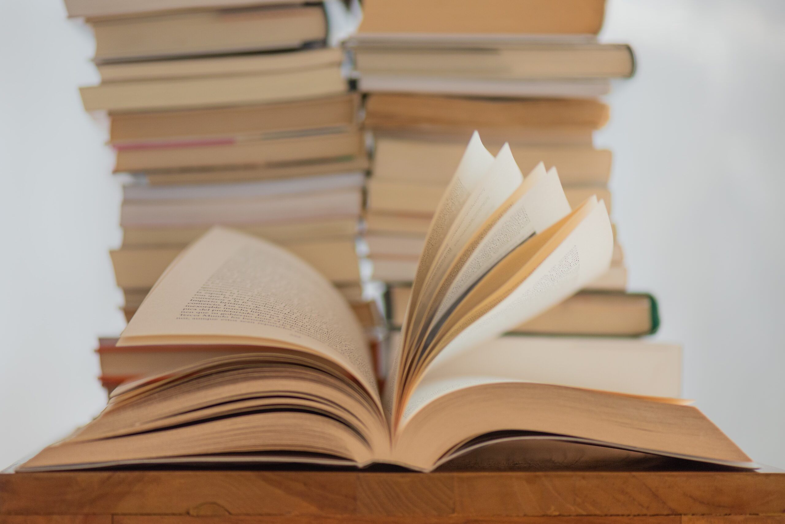 a photo of a stack of books with book open in front of them 