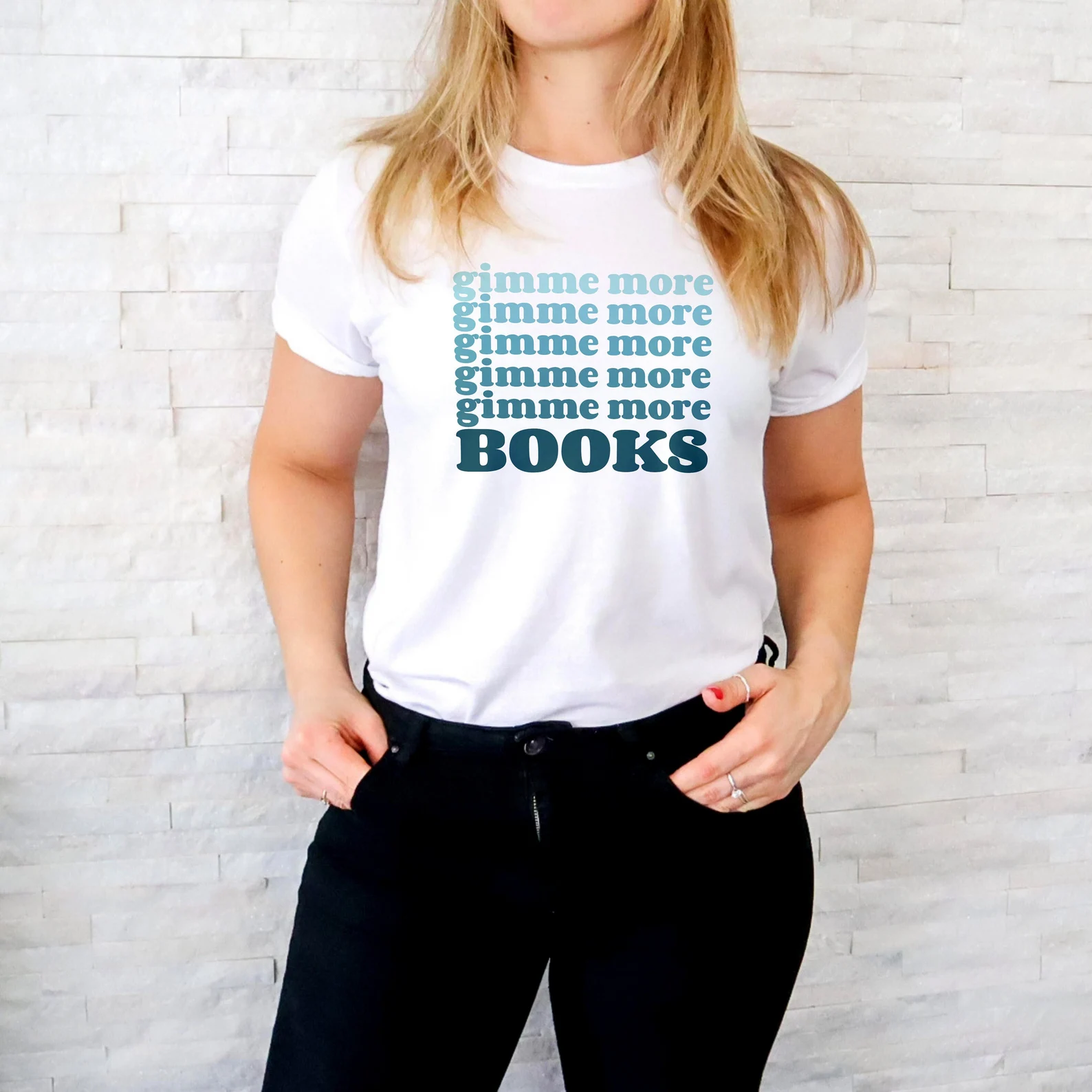 white t-shirt with blue-green lettering that says "gimme more books"