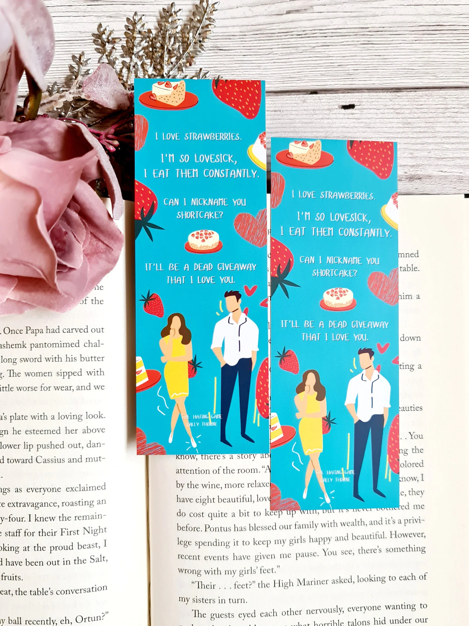 A blue bookmark decorated with strawberry shortcake and a quote from THE HATING GAME