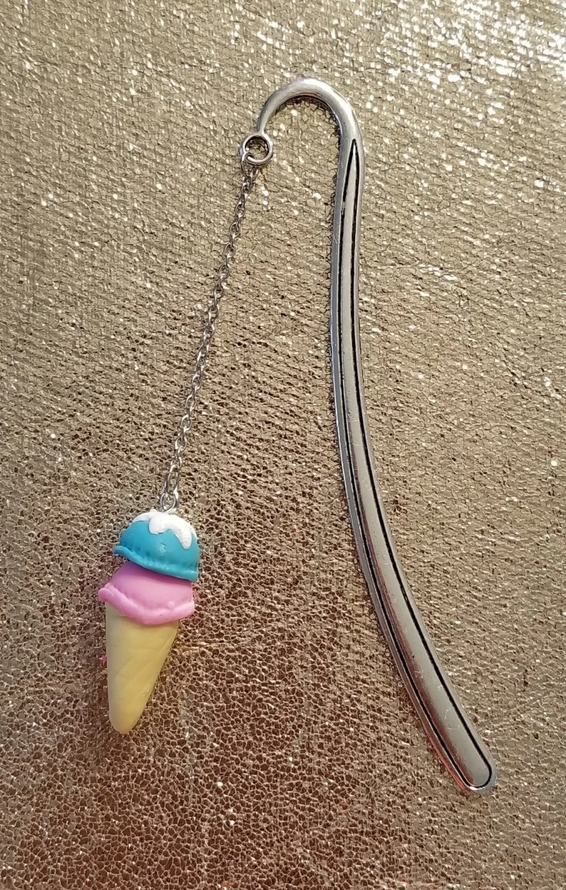 Image of a metal bookmark with a long tassel. There is an ice cream cone charm. 