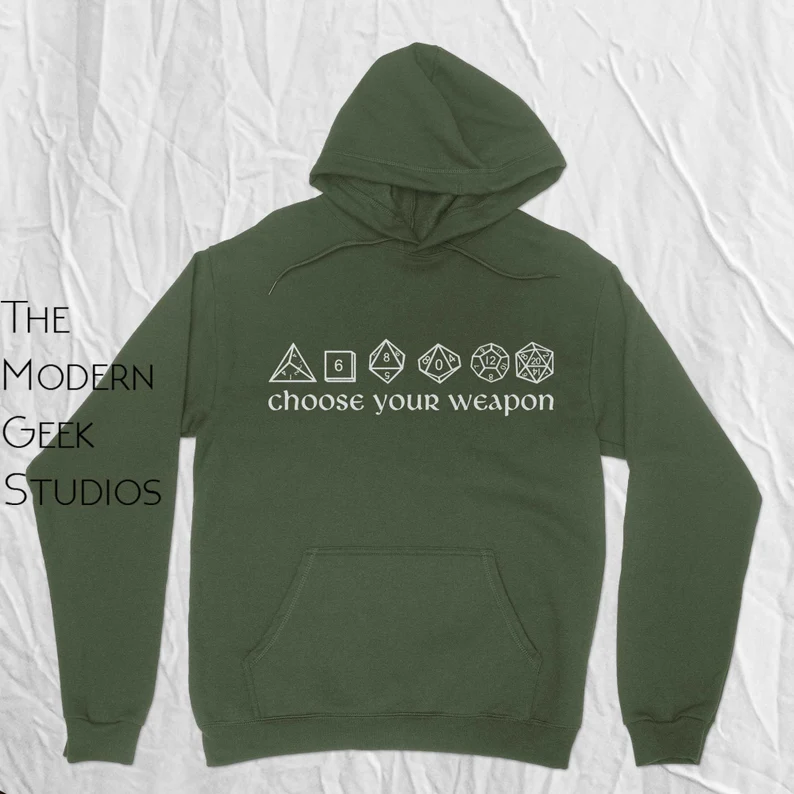 photo of a green hoodie with an illustration of a line of D&D dice. underneath the dice reads the text, "choose your weapon"