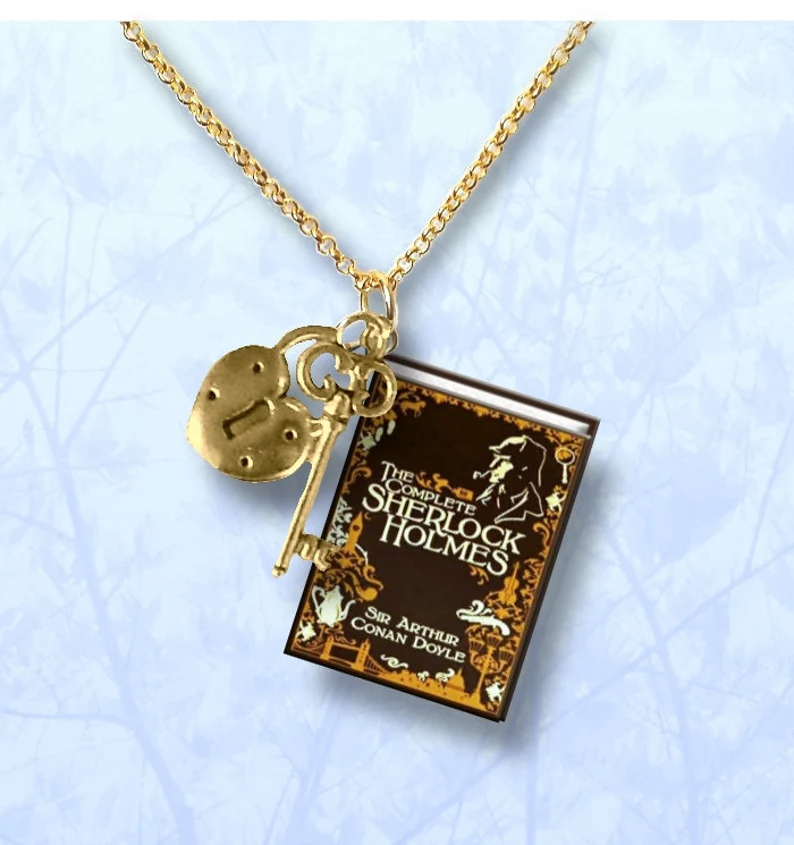 photo of a necklace with a lock and key charm and a miniature Sherlock Holmes book