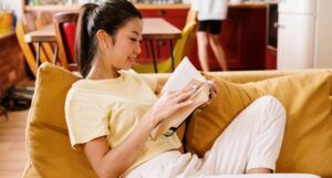 Image of Asian woman reading on a couch