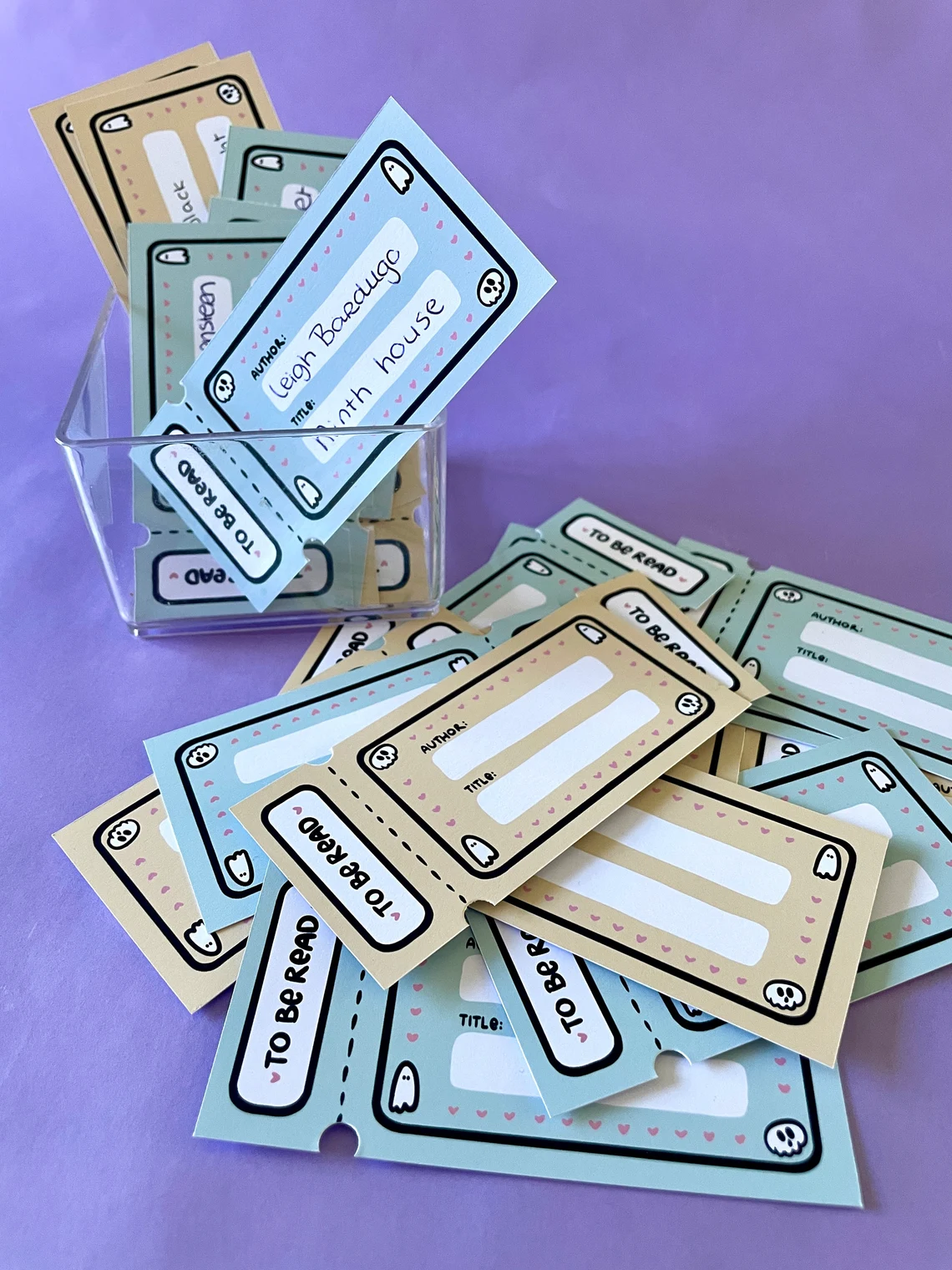 Image of a set of cards all designed like a movie ticket. They are cream and blue, with space for an author and title. The corners of the tickets have cute little ghosts. 
