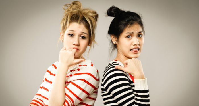 image of teen girls standing back to back