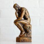 a photo of a small version of the Thinker statue