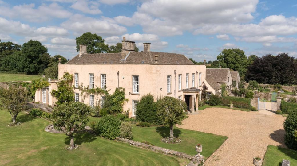 a photo of the largest building on the property, surrounded by fruit trees