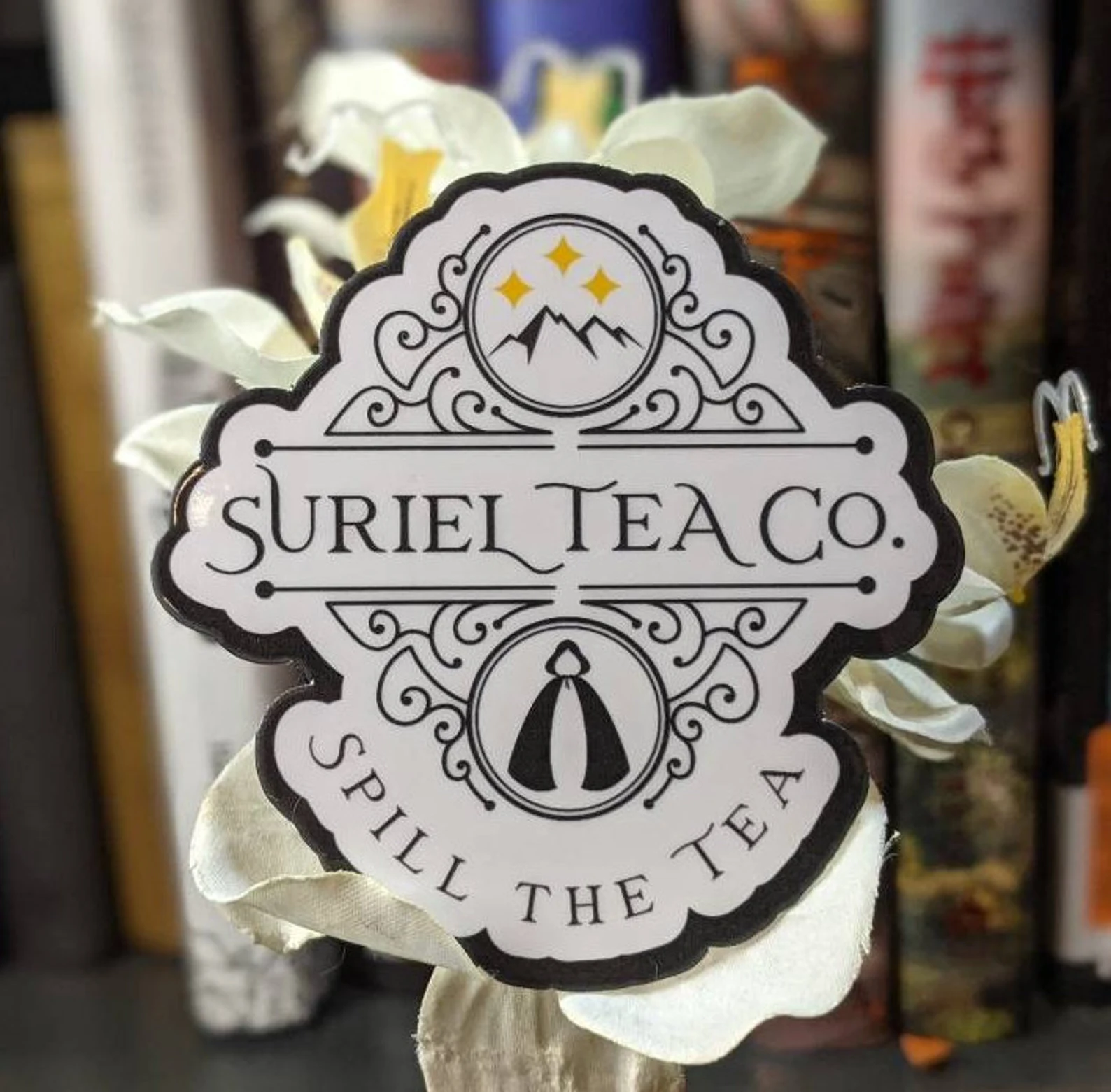 a white sticker that reads "Surreal Tea Co" and depicts stars and mountains in the background