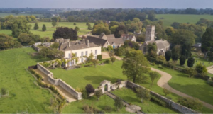 an aerial shot of the estate, showing several buildings, a walled in property, and a large manicured lawn