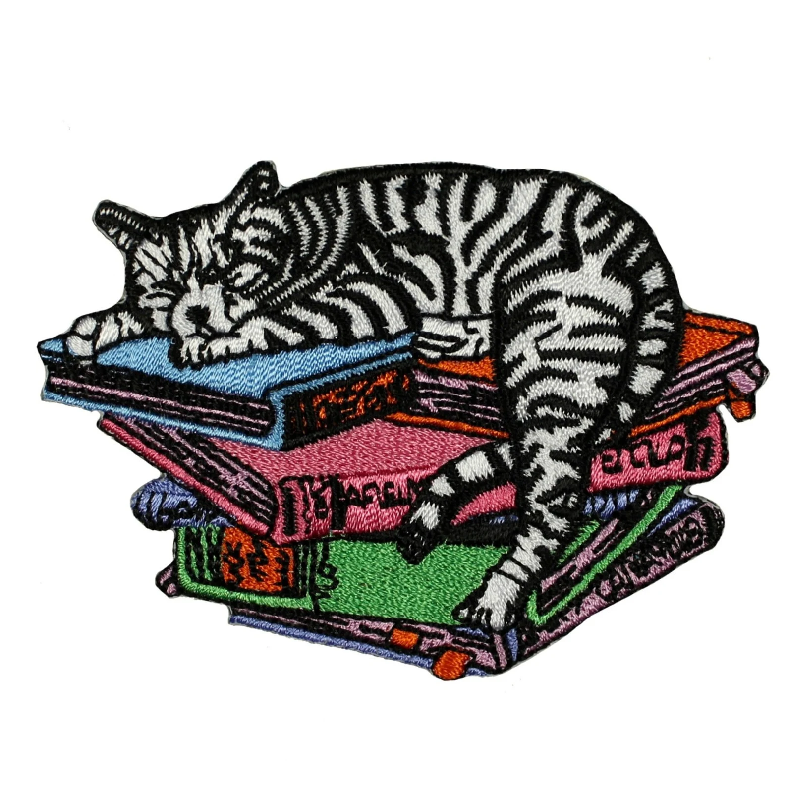 Image of a striped cat on top of a colorful stack of books. It is an iron on patch. 