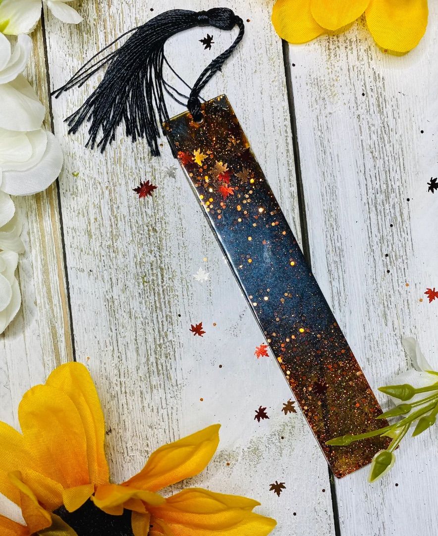 Image of a darker colorway resin bookmark with fall leaves. 
