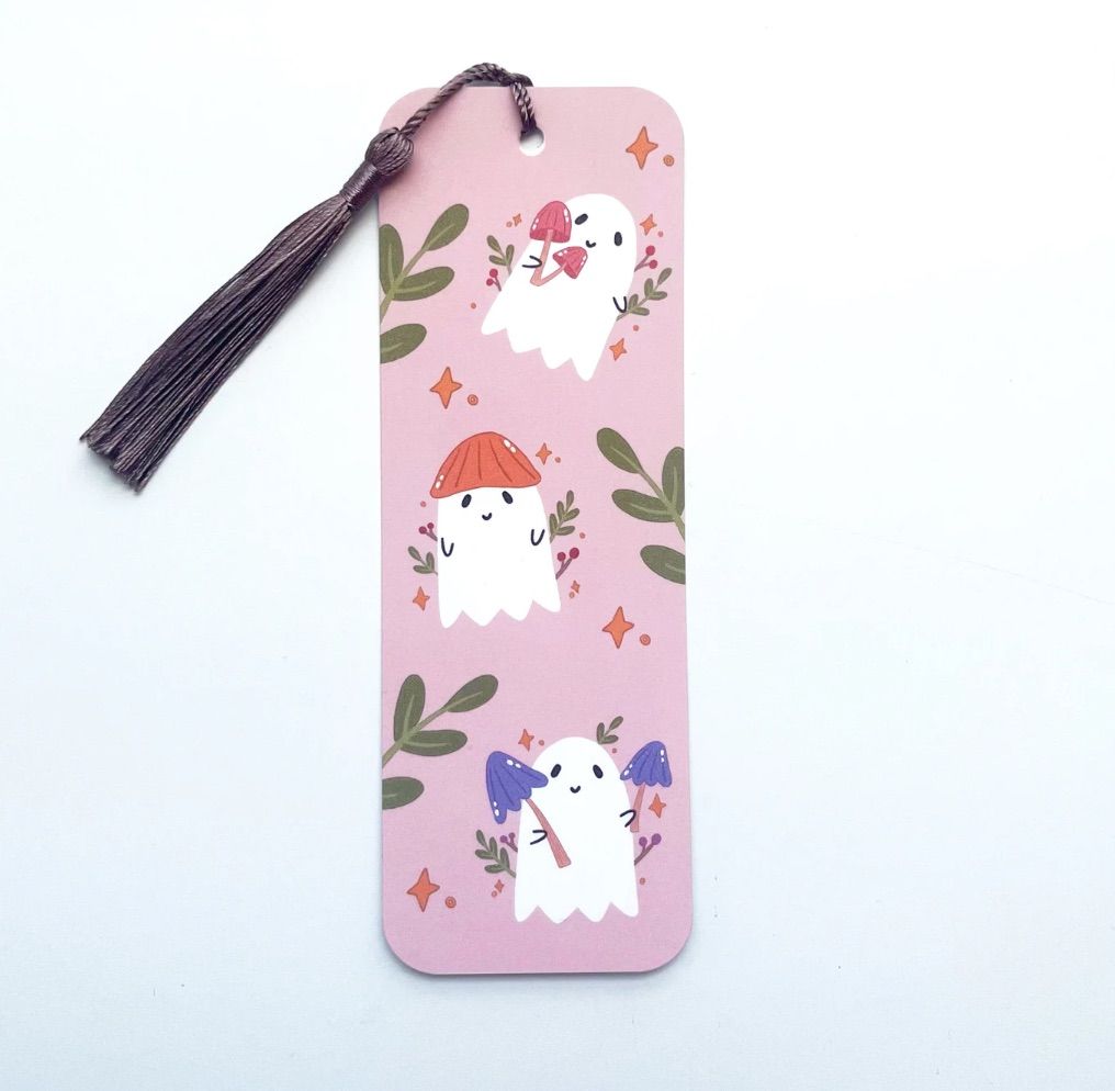 Image of a pink bookmark with ghosts wearing mushrooms. 