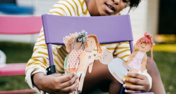 Image of a child with several paper dolls