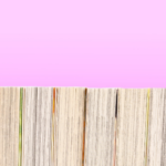 a photo of a bookshelf of manga from behind with a pink background