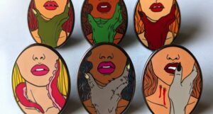 monster lover enamel pins with women of varying skin tones who are paired with different kinds of monsters' hands