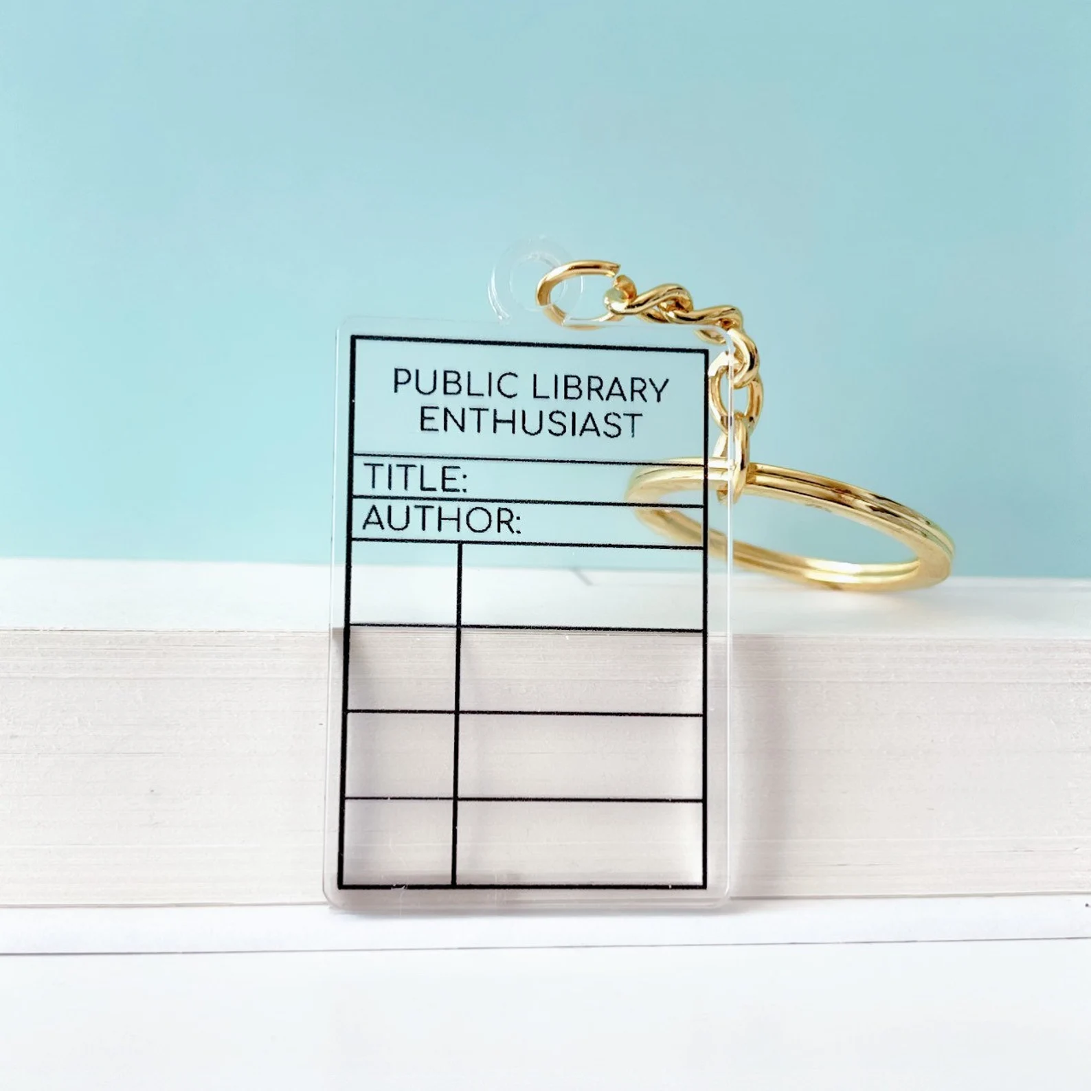 A clear plastic keychain in the shape of a library card.