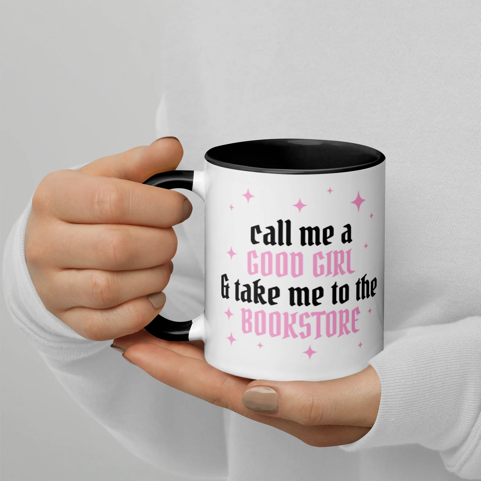 A black and white mug with pink text that reads "call me a good girl and take me to the bookstore"