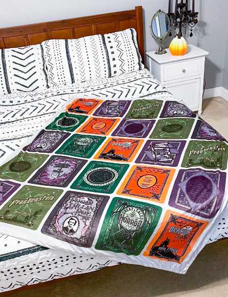 A throw blanket with colorful covers of horror classics like Dracula and Frankenstein
