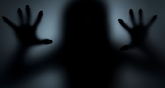creepy hands and silhouette of body on glass