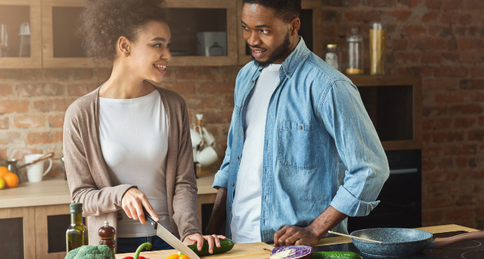 a photo of a Black couple cooking together