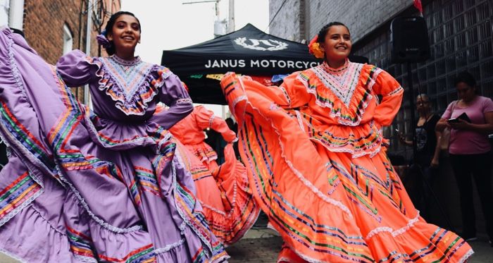 two young Latine dancers in colorful dresses