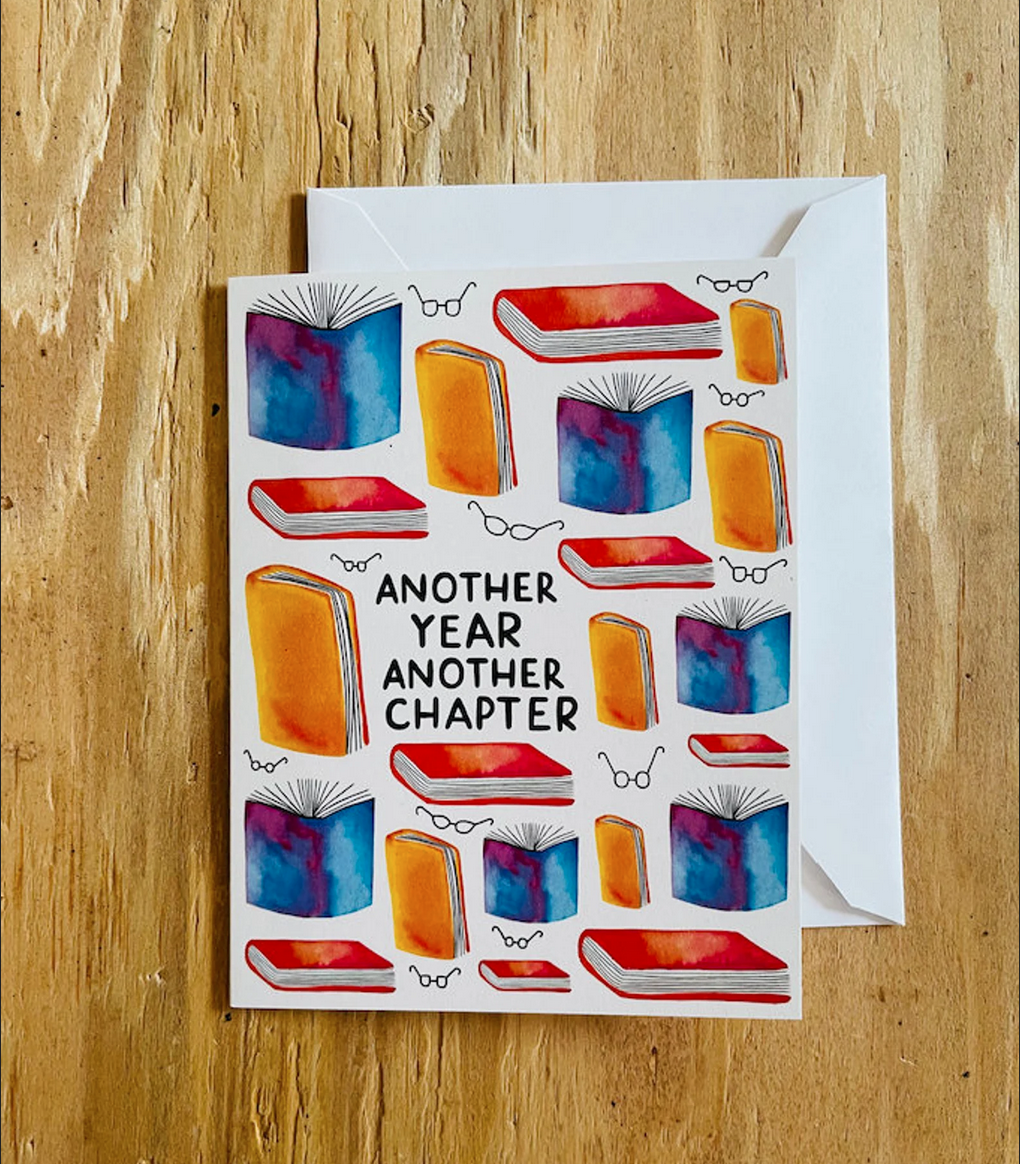 Hand-painted card reading "Another Year Another Chapter"