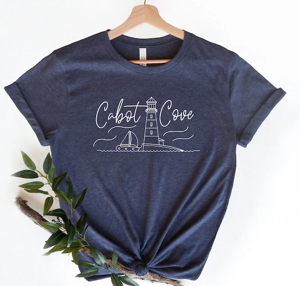 blue tee with a doodle of a lighthouse that says Cabot Cove