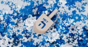 dreidel that says "hey" on a blue and white background