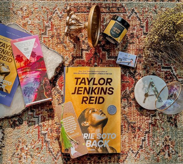 a photo of an Authentic Books book box, featuring Carrie Soto Is Back surrounded by a matching bookmark, candle, chocolate bar, and more goodies