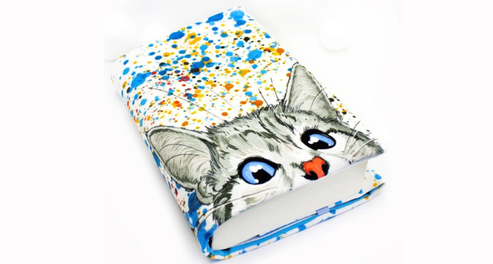 a photo of a book sleeve with a cat face illustration and colorful paint splashes