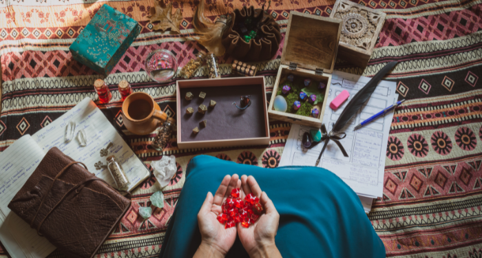 a photo of someone holding dice surrounded by DnD accessories