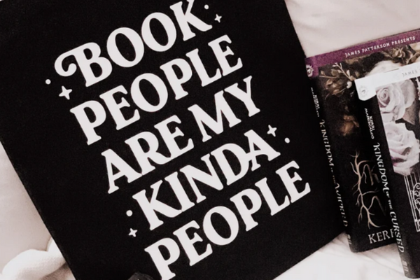 Black tote bag with white text reading 