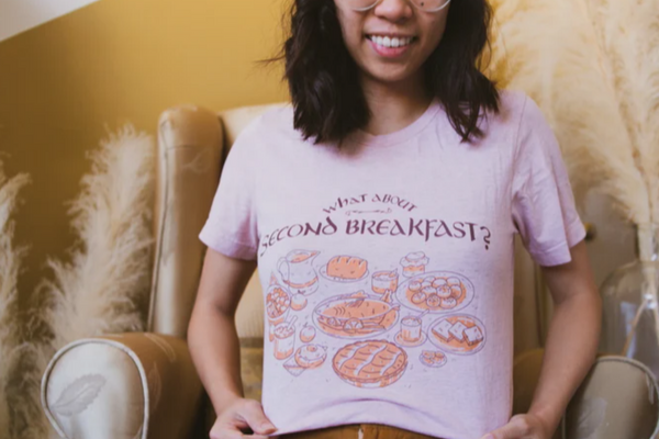 Tee-shirt featuring a spread of yummy looking illustrated food and drinks underneath the text 