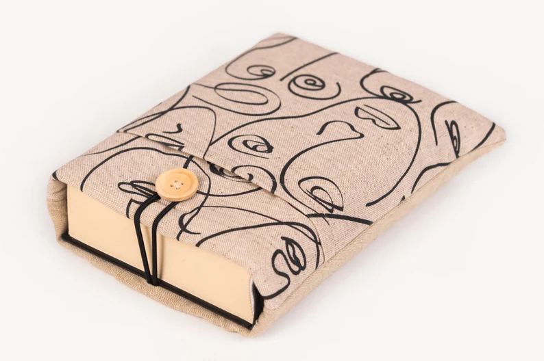 Photo of a beige book sleeve with a print of an abstract face
