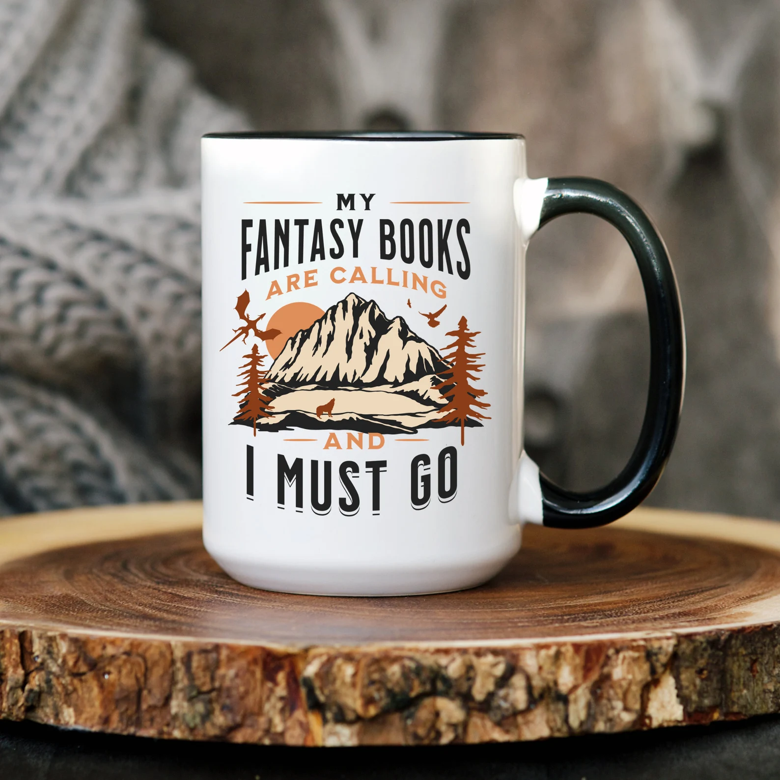 a photo of a mug with an image of a fantasy scene and the words, "My fantasy books are calling and I must go"