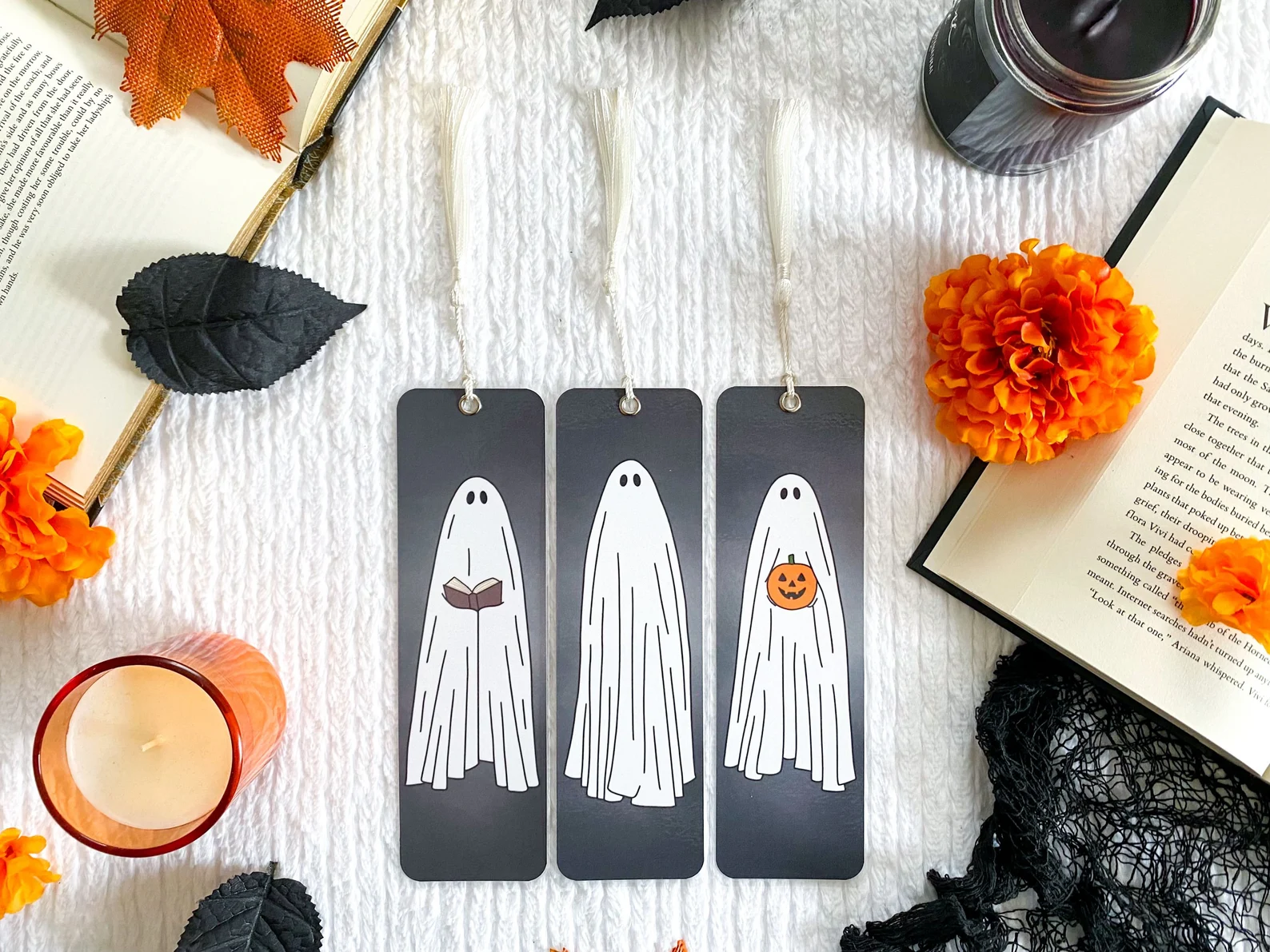 Set of three bookmarks depicting sheet ghosts, one holding a book and another holding a pumpkin