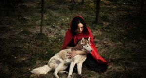 Image of a person in a red hood with a wolf