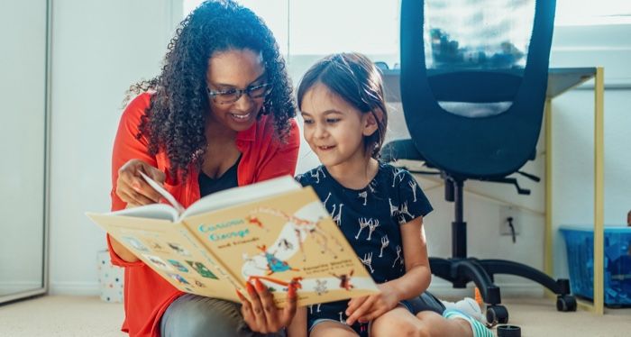 brown-skinned lady reading to little girl
