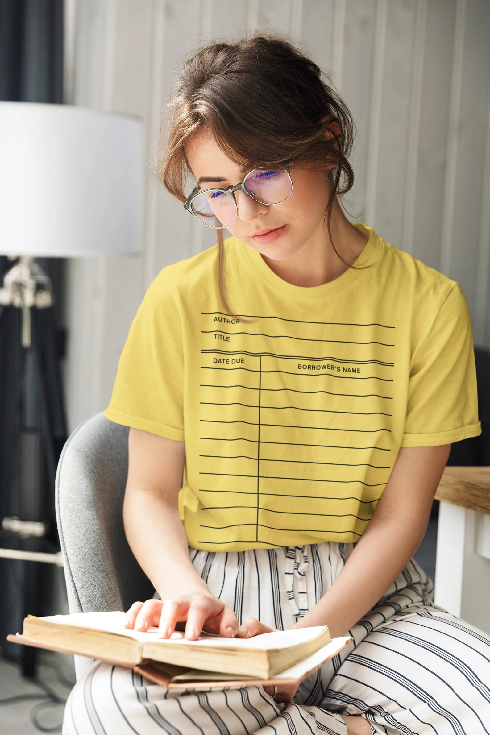 A yellow t-shirt with an imprint of a library checkout card