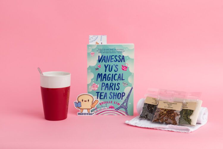 a photo of a mug, tea bags, a bread slice sticker, and the book Vanessa Yu's Magical Paris Tea Shop