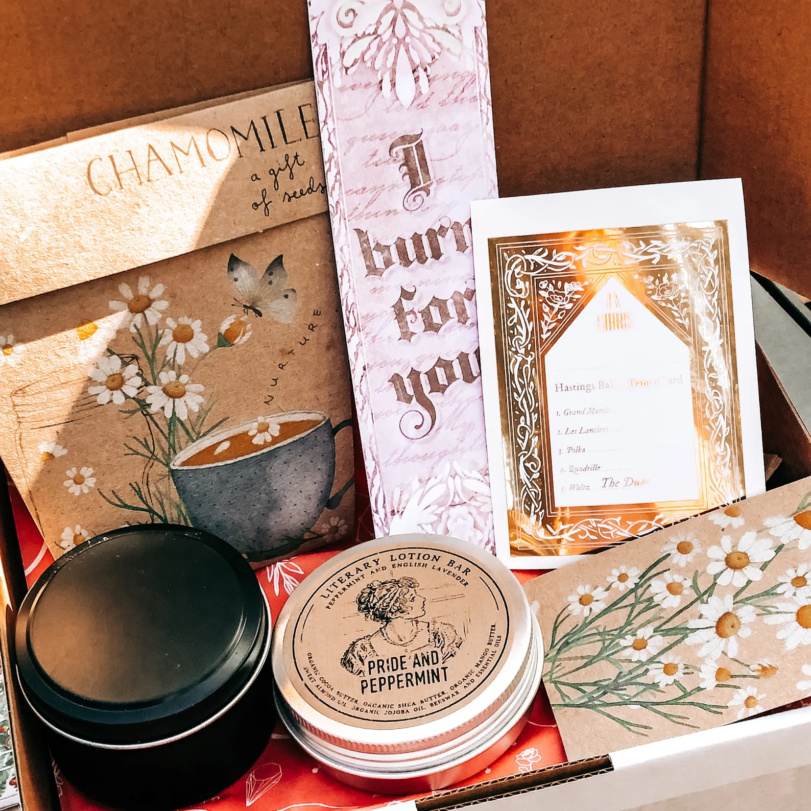 A bundle of tea, bookmark, candle, and a card